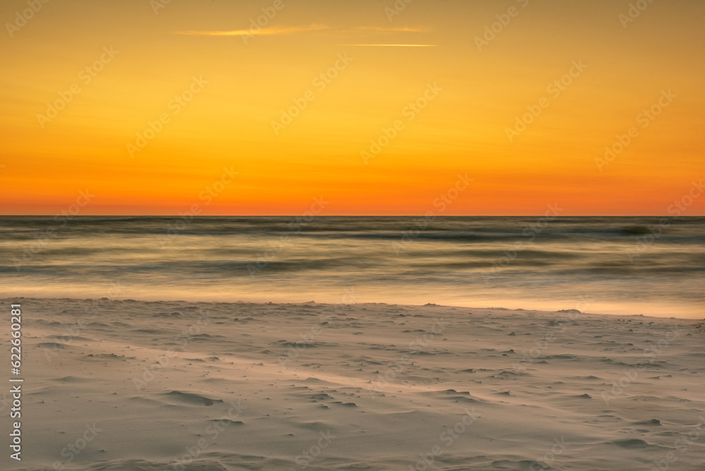 sunset over the sea, the wind carries the sand - obrazy, fototapety, plakaty 