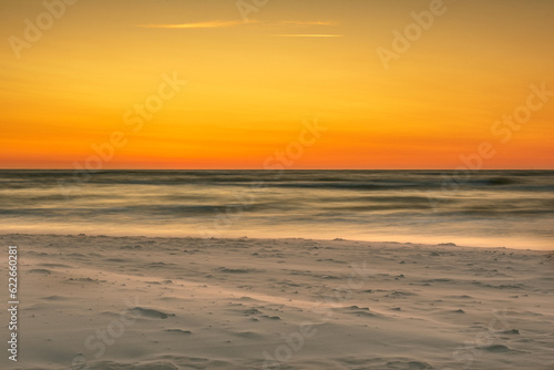 Fototapeta Naklejka Na Ścianę i Meble -  sunset over the sea, the wind carries the sand