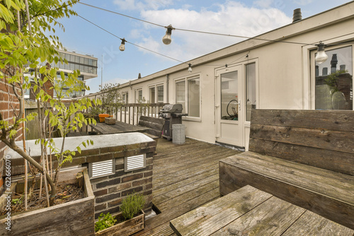 an outside area with wooden decking and white siding on the side of a house that is being used for storage