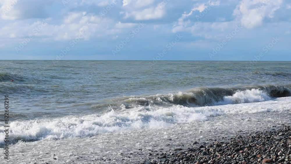 Stormy gray sea, strong waves crashing on the rocky beach Stormy gray sea, strong waves crashing on the rocky beach