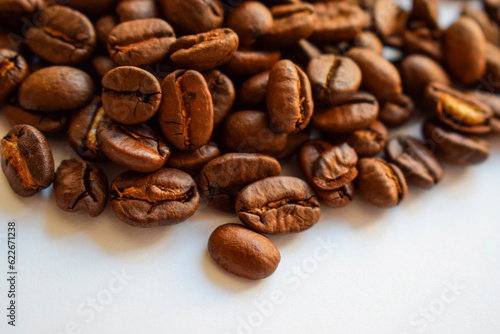 Handful of aromatic brown roasted coffee beans close up isolated on white background horizontal banner top view