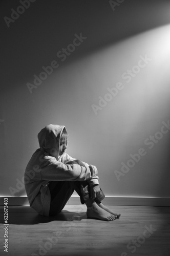 menino sozinho triste em depressão sentado no chão, problemas na infãncia e na adolescencia  photo