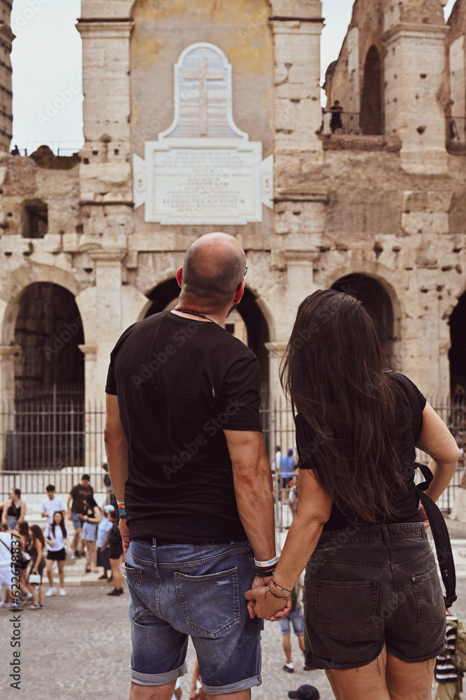 Happy  Beautiful Tourists  couple traveling at Rome, Italy, poses in front of  Colosseum  at, Rome, 