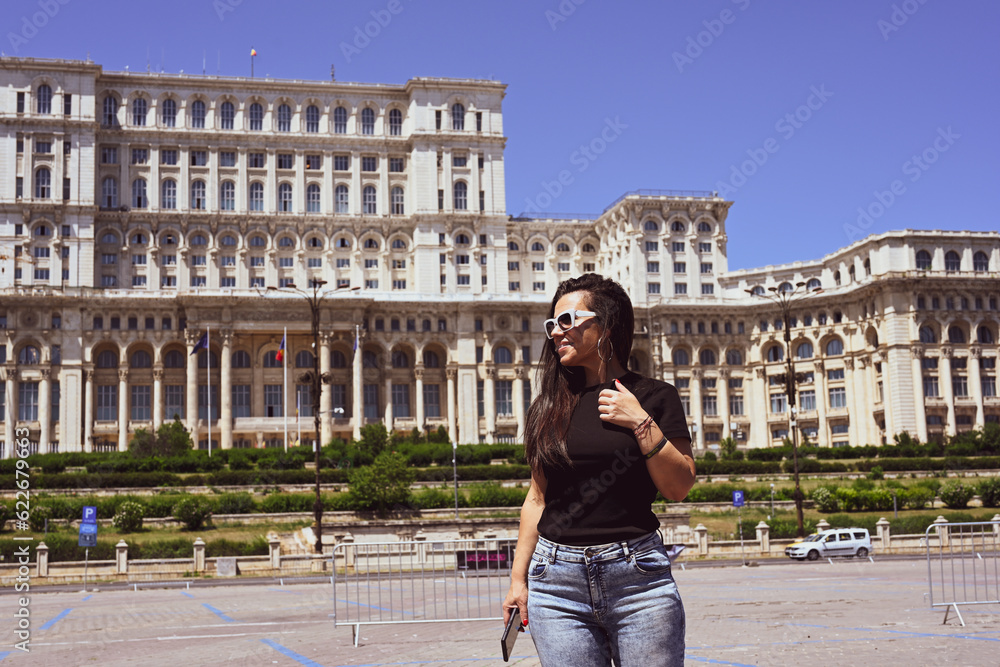   Bucharest ,Romania Constitution Square.  Young beautiful smiling  woman  using a mobile phone taking a pictures.Concept of Romanian gastronomy and trave