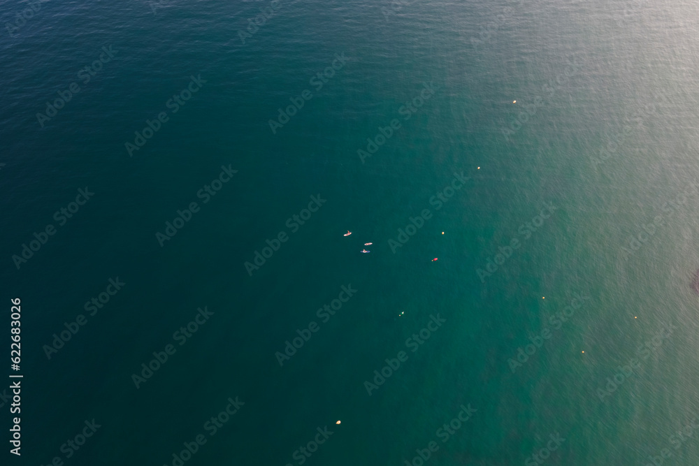 Aerial view of people with a canoe at sunset along the coastline in Sitges, Barcelona, Spain. Aerial view of people with a canoe at sunset along the coastline in Sitges, Barcelona, Spain.