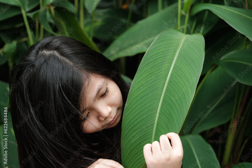 Portrait of a Cute Asian Thai Look and feel the green leaves.. Portrait of a Cute Asian Thai Look and feel the green leaves..
