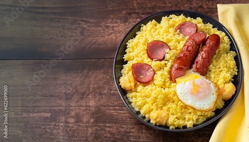 Foto couscous with scrambled eggs and pepperoni sausage on dark wood and fabric ( cuz