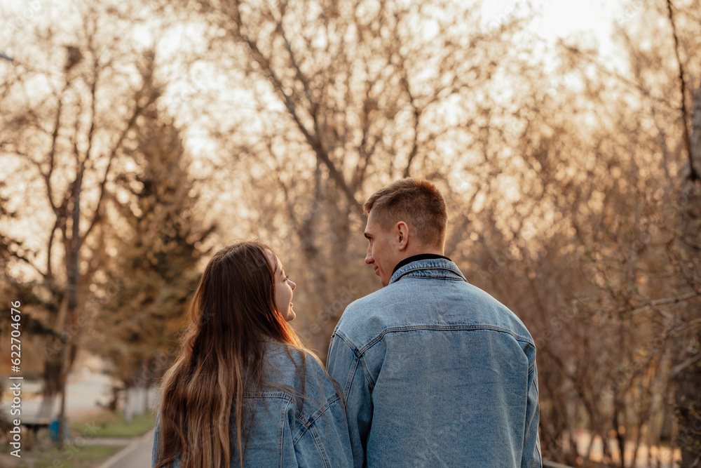 A couple in motion walks in the park in spring or autumn, happy lifestyle concept A couple in motion walks in the park in spring or autumn, happy lifestyle concept