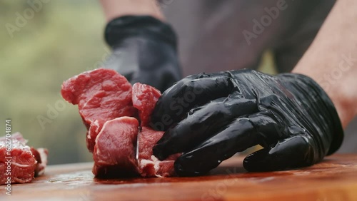 Close-up video of raw meat cutting with a knife in an abattoir doing butchering and trimming of beef in the meat industry. Meat preparing for cooking