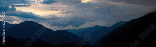 Mountain landscape view panorama background - Sunrise or sunset with silhouette of mountains alps  cloudy sky