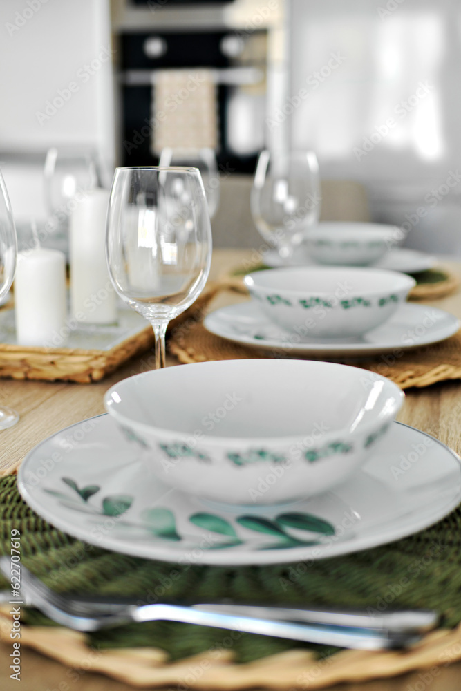 Empty wine glasses and dinnerware is ready for lunch served on dining table, no people, close up vertical view Empty wine glasses and dinnerware is ready for lunch served on dining table, no people, close up vertical view