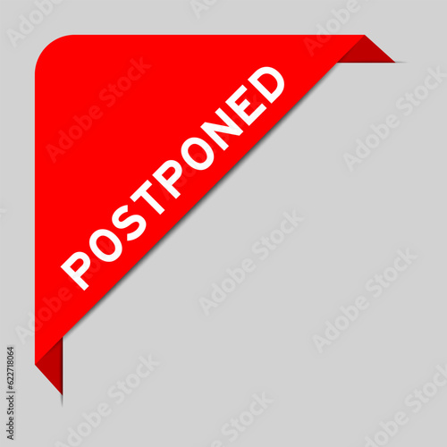 Red color of corner label banner with word postponed on gray background