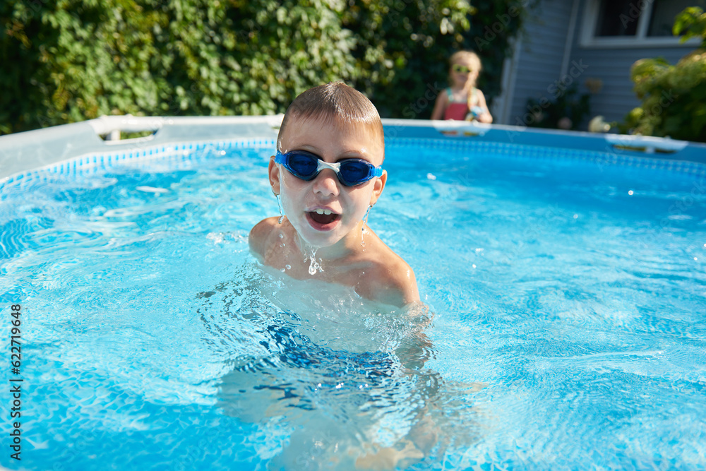 8 year old boy dives out of the pool wearing swimming goggles
