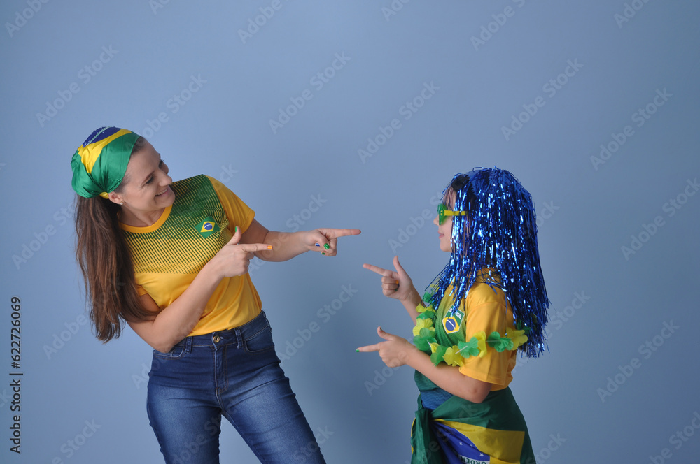 mãe e filha celebranco vitória do brasil, juntas comemorando gol do brasil em copa do mundo  - obrazy, fototapety, plakaty 