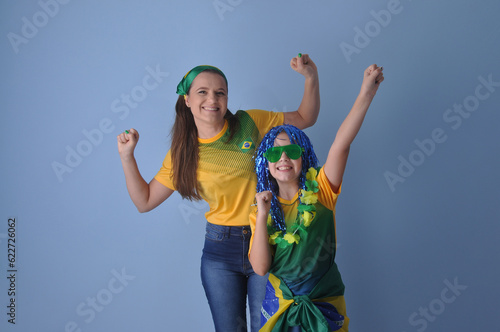 mãe e filha celebranco vitória do brasil, juntas comemorando gol do brasil em copa do mundo  photo