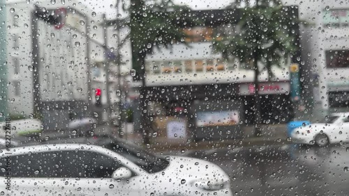 Bus window with rain and moving traffic