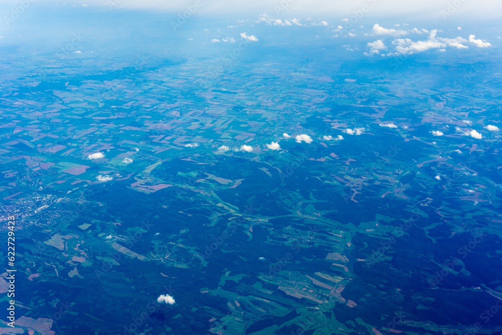 Fototapeta premium View to a land and clouds from airplane