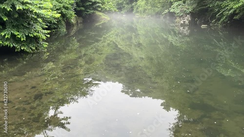River tilt up shot, misty atmosphere.