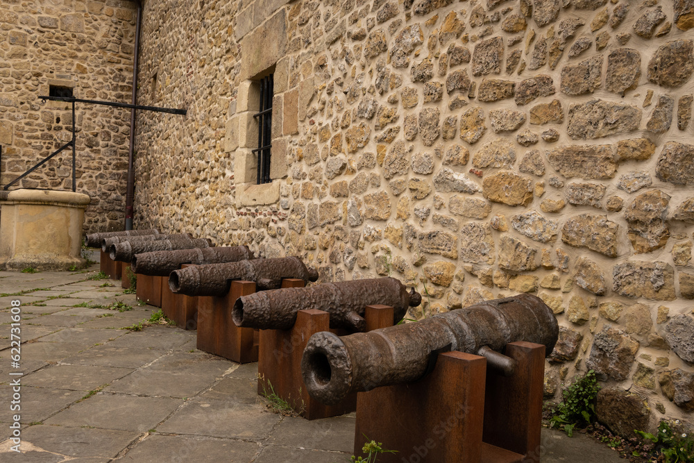Fototapeta premium Antique cannon artillery defensive weapon on wall of cultural historic fort building Castillo de la Mota on Mount Urguell in front of bahia de la concha Donosita-San Sebastian Spain. 