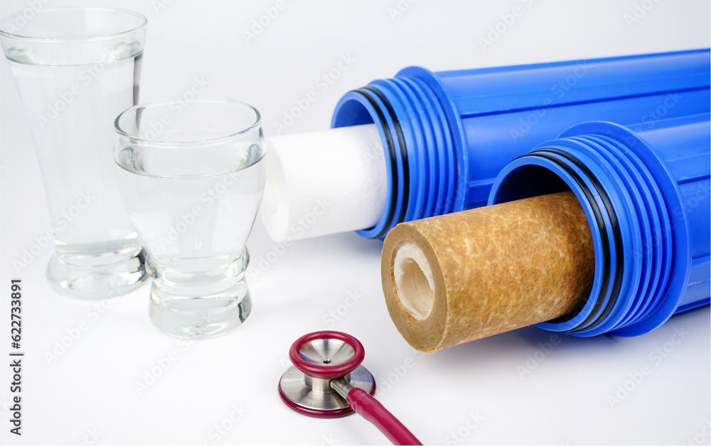 Carbon cartridge and water glass with stethoscope  on white background. Cleaning inspection quality of household water filtration systems.Testing of Carbon cartridge  filters, checking,drinking water.