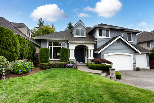 Beautiful home with green grass yard and blooming hydrangea flowers