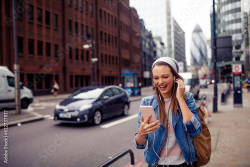 Young woman using a phone while walking in the city london © Geber86