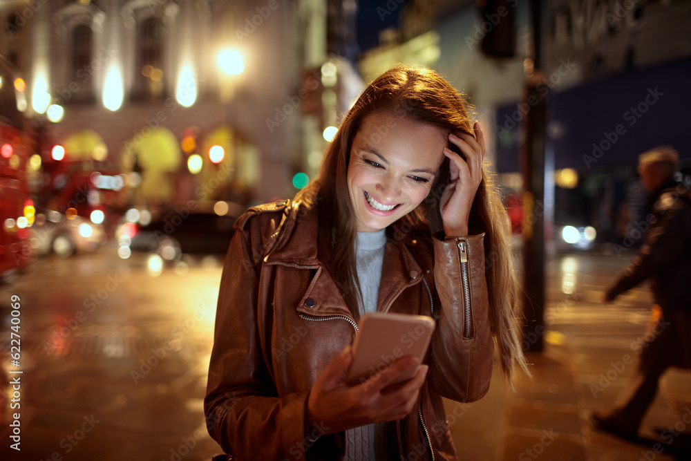 Obraz premium Young woman using a smart phone while walking in the city london