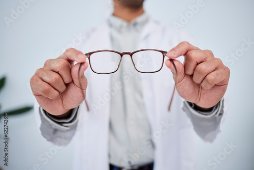 Hands, person and optometrist with glasses for vision, eyesight and prescription eye care. Closeup of doctor, optician and frame of lens, eyewear test and consulting for optical healthcare assessment