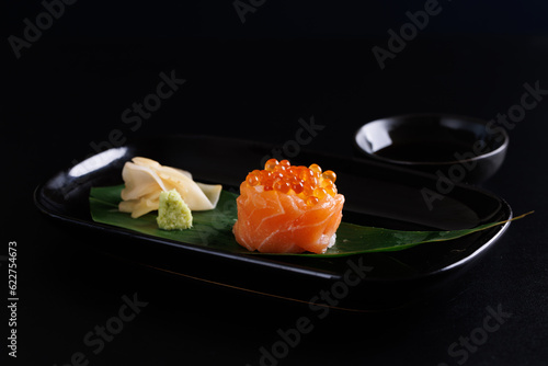 Salmon Sushi roll with caviar topping Japanese food isolated in black background