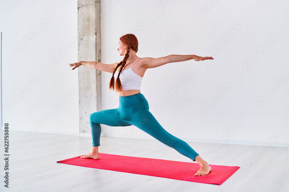 Flexible sports young woman practices yoga exercise in studio class Flexible sports young woman practices yoga exercise in studio class
