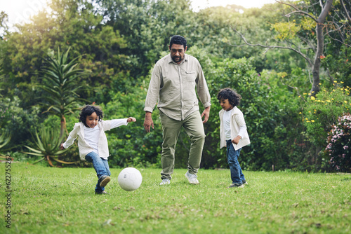 Happy, soccer and father with children in garden for playful, learning and sports. Summer, fitness and family with man and kids playing football in backyard at home for teaching, workout and growth