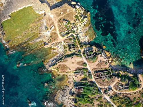 Aerial view of ruins houses along Massolivieri beach with high cliffs along the coastline in Syracuse, Sicily, Italy. photo