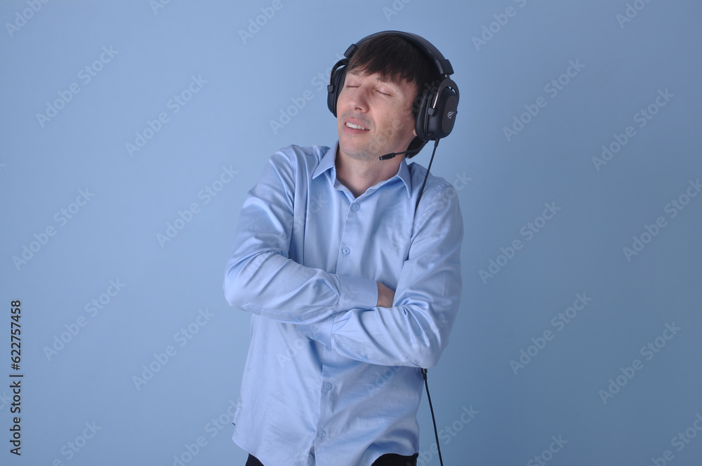Jovem bonito vestindo suéter casual sobre fundo azul rosto feliz sorrindo. Pessoa positiva, fones de ouvido Jovem bonito vestindo suéter casual sobre fundo azul rosto feliz sorrindo. Pessoa positiva, fones de ouvido