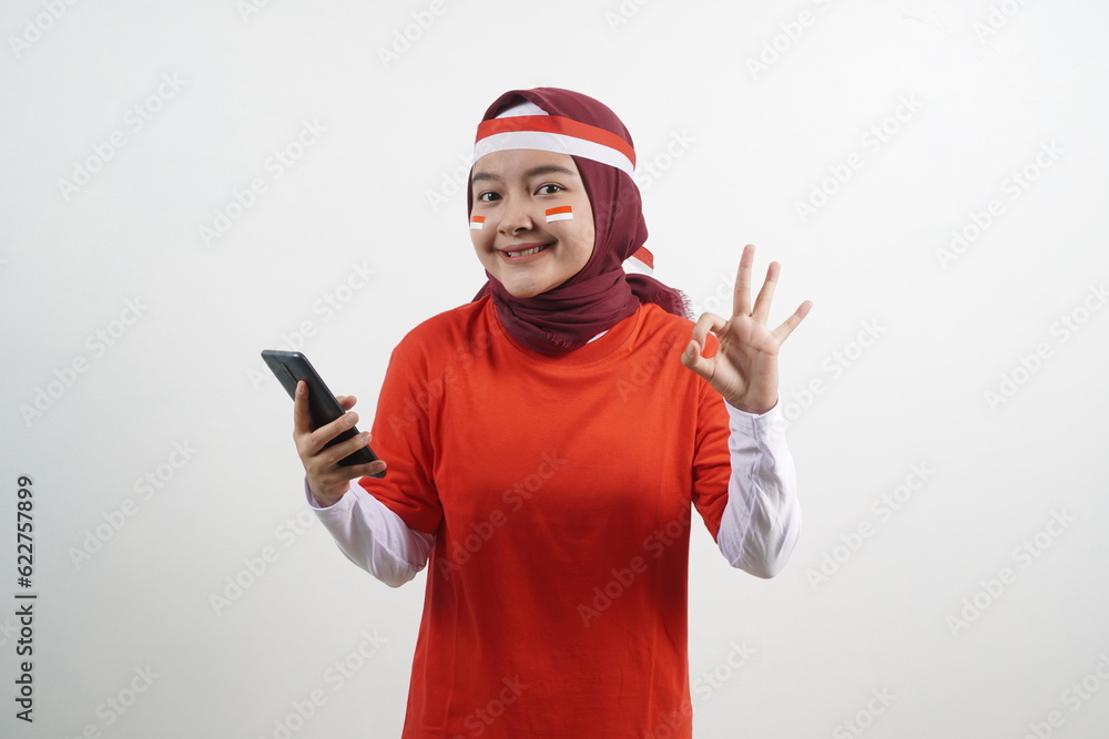 Woman holding phone, okay gesture, indonesian independence day Woman holding phone, okay gesture, indonesian independence day