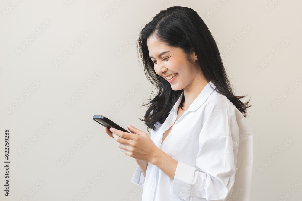 Happy smile asian young woman using mobile smart phone, read good news online feel getting offer, great positive surprise, celebrate success on smartphone. Businesswoman isolated on white background. Happy smile asian young woman using mobile smart phone, read good news online feel getting offer, great positive surprise, celebrate success on smartphone. Businesswoman isolated on white background.