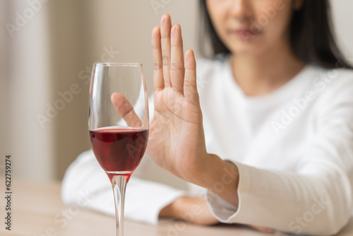 Alcoholism, depressed asian young woman hand refuse red wine or alcoholic beverage, female drinking whiskey and quit booze. Treatment of alcohol addiction, having suffered abuse problem alcoholism.