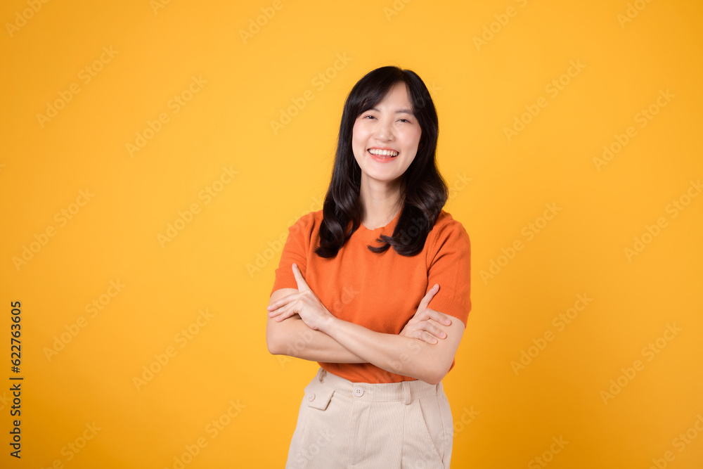 portrait cute attractive young 30s businesswoman happy smile face showing arm crosses expression successful business work isolated on yellow background. portrait cute attractive young 30s businesswoman happy smile face showing arm crosses expression successful business work isolated on yellow background.