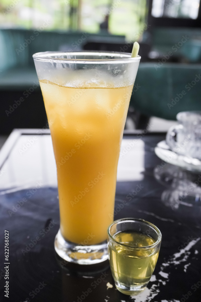 Wedhang Jahe Serai in a long glass or Cold Lemongrass Ginger drink. Traditional drink used as herbal medicines for health, relaxation and stamina or to overcome body chills. Close-up photo. Wedhang Jahe Serai in a long glass or Cold Lemongrass Ginger drink. Traditional drink used as herbal medicines for health, relaxation and stamina or to overcome body chills. Close-up photo.