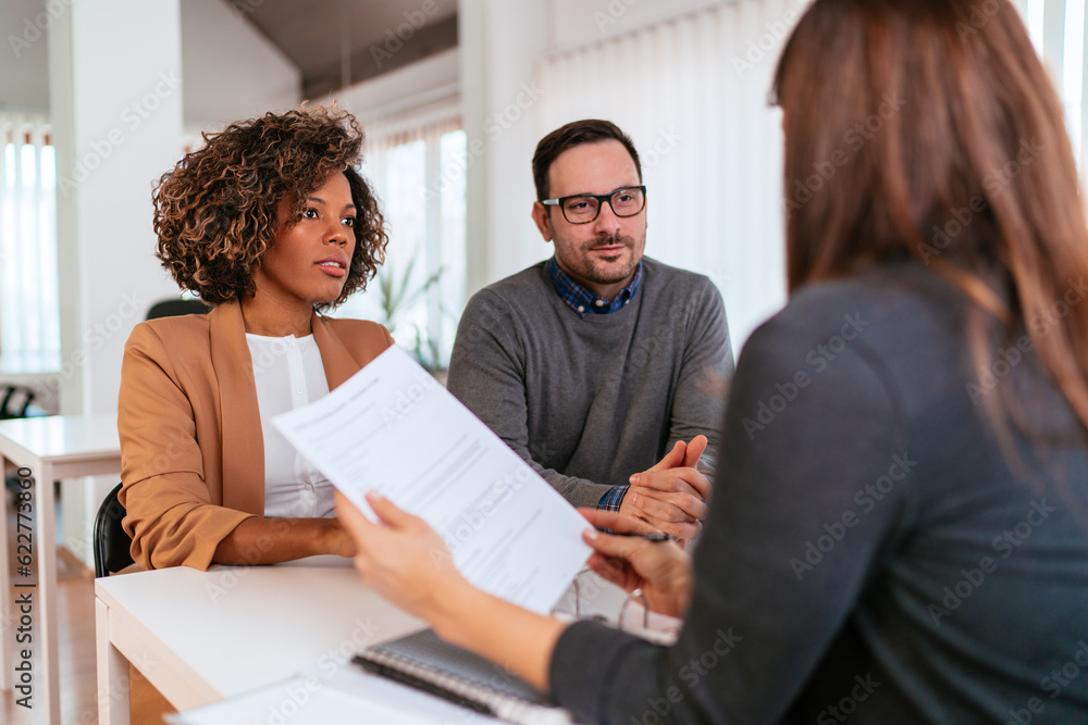 © kerkezz - Couple consulting with a female financial manager at the bank