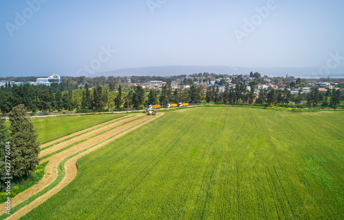 Aerial view of a agricultural machinery at action in a wheat field, kibbutz saar, Israel. photo