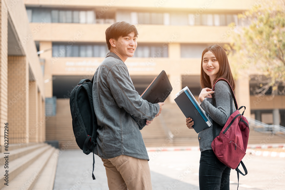 Education and Learning, Student, Campus, University, Lifestyle concept. Portrait of two students holding book and laptop talking together discussing about exam preparation, study for test preparation