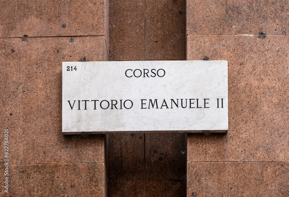 marble sign pointing to Milan's centrally located Corso Vittorio Emanuele, a famous pedestrian shopping street, that connects Piazza San Babila and Piazza del Duomo.
