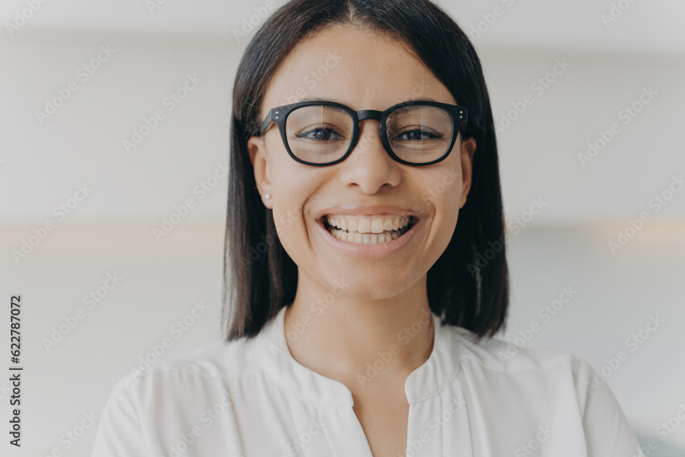 Happy businesswoman in glasses smiles, looking at the camera with a friendly, toothy smile. Laughing female promotes eyeglass store, emphasizing eye sight correction. Happy businesswoman in glasses smiles, looking at the camera with a friendly, toothy smile. Laughing female promotes eyeglass store, emphasizing eye sight correction.