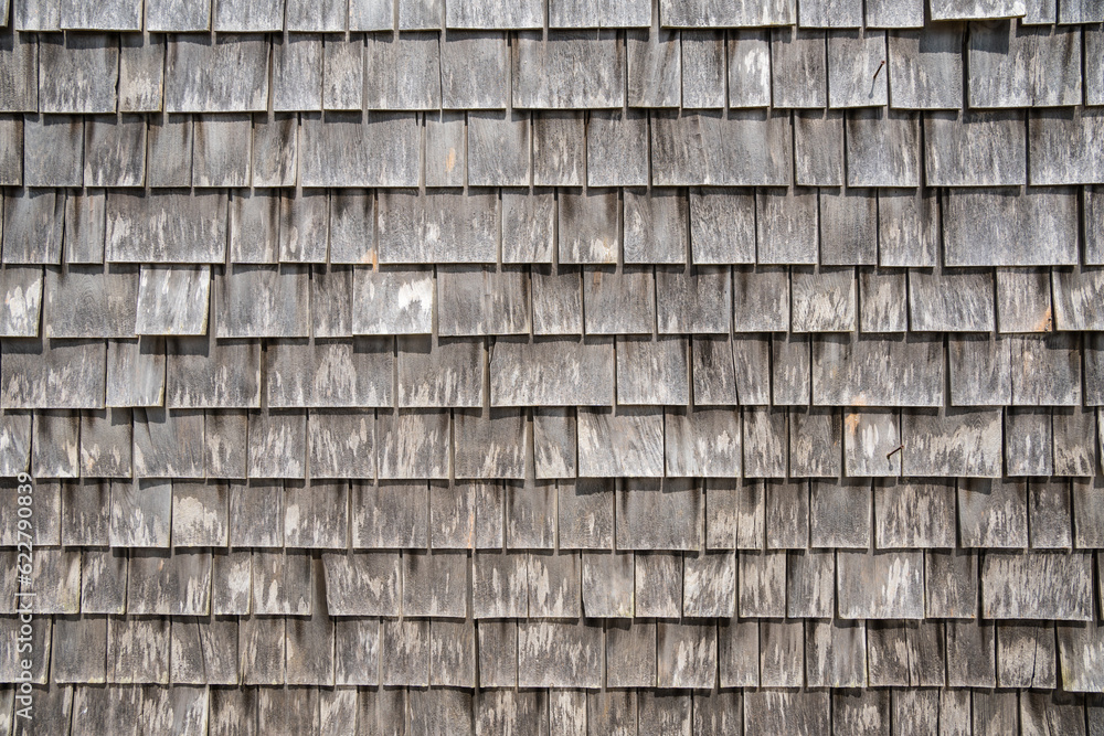 Close-up view of large gray weathered shingles on typical Cape Cod building in quaint fishing village on Martha's Vineyard, Massachusetts.
Close-up view of large gray weathered shingles on typical Cape Cod building in quaint fishing village on Martha's Vineyard, Massachusetts.