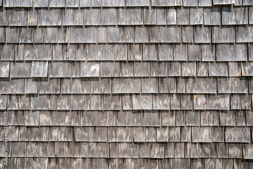 Close-up view of large gray weathered shingles on typical Cape Cod building in quaint fishing village on Martha's Vineyard, Massachusetts.
 photo