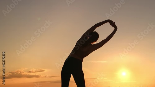 Athletic muscular female sport exercising outdoor workout physical activity sunset sunrise sun sky
