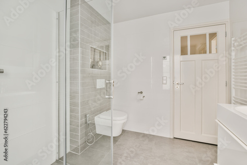 a modern bathroom with white walls and grey flooring  including a glass shower door that opens to the walk - in shower area