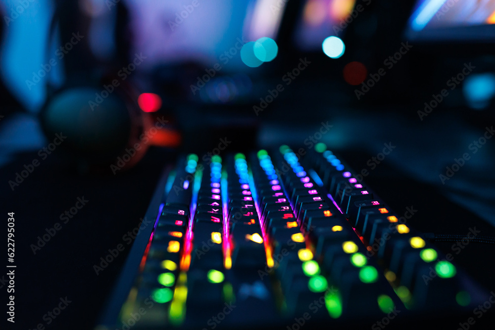 Computer mouse, keyboard, neon-illuminated headphones for esports, concept of a professional game.