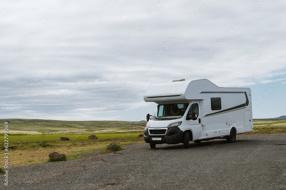 Beautiful nature in Iceland. Scenic Icelandic landscape at cloudy day. Modern caravan on asphalt parking lot. Travel in mobile home