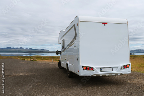 Beautiful nature in Iceland. Scenic Icelandic landscape at cloudy day. Modern caravan on asphalt parking lot. Travel in mobile home